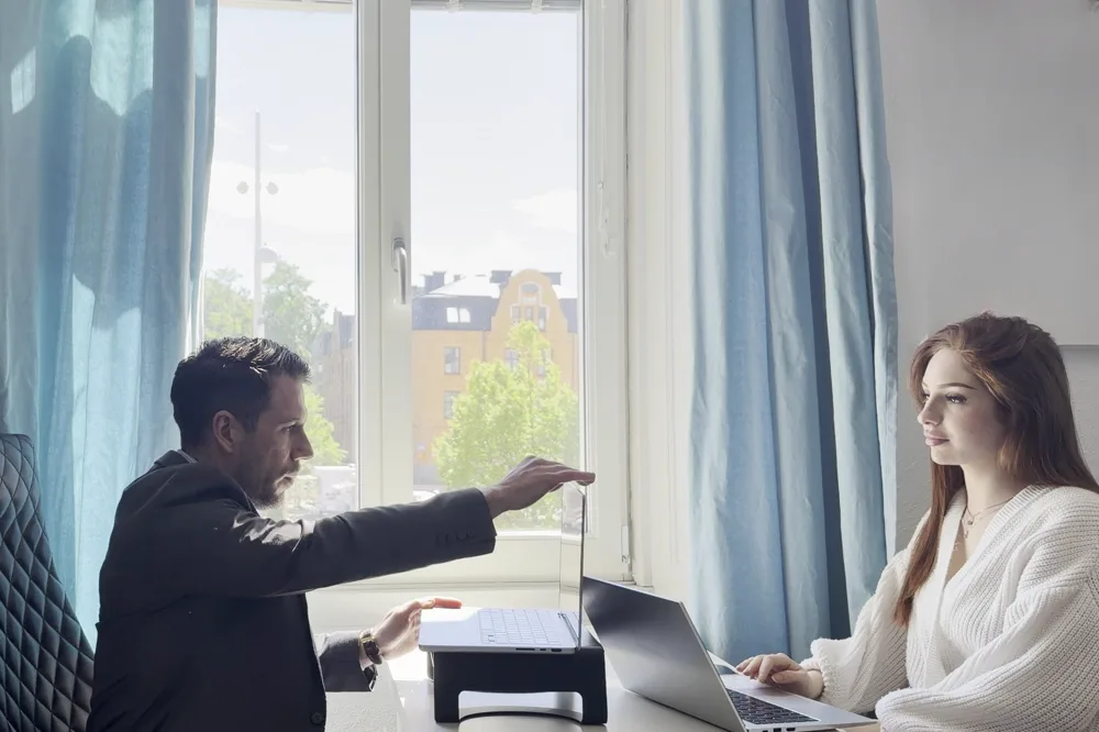 Joakim Jaksen i ett samtal med en kollega vid fönstret på Synlighetsverkets kontor i Uppsala